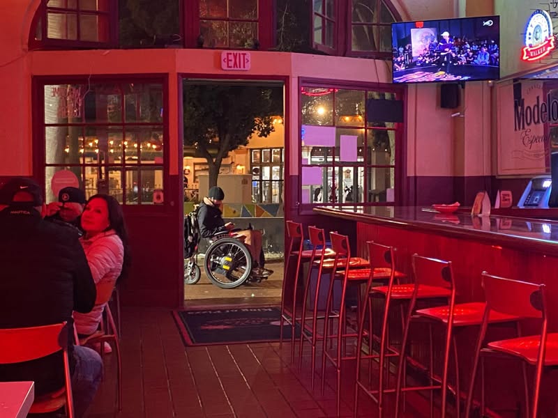 The warm glow of the bar lights spills out onto…